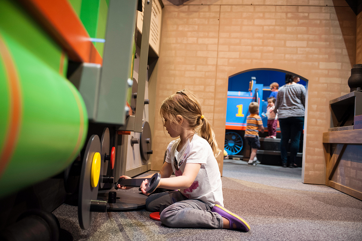 girl changing Percy's wheel in the exhibit